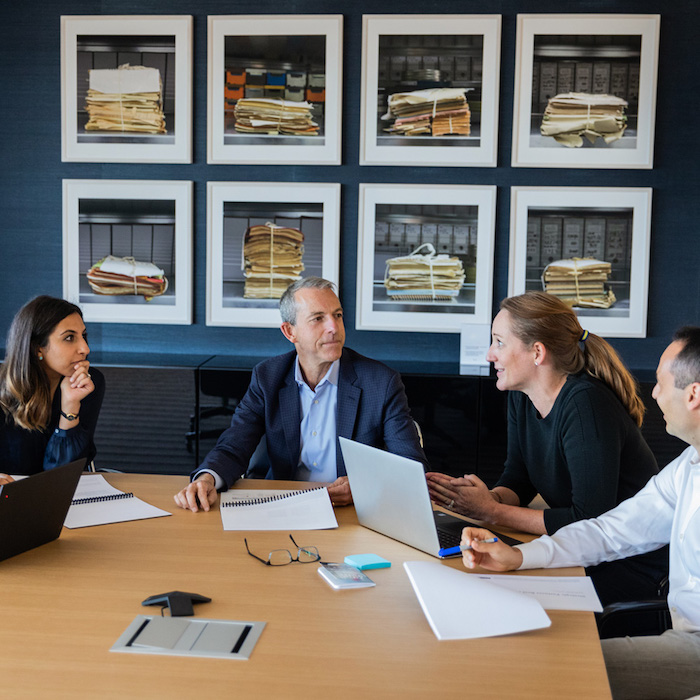 A group of people are discussing business at a meeting table