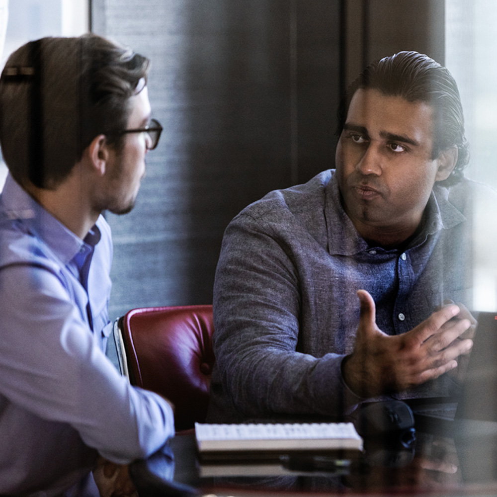 Two smiling men at a conference table